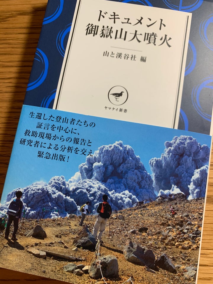 『ドキュメント御嶽山大噴火』の表紙。登山者が撮影した噴火直後の写真には、噴煙を見上げ立ちすくむ人たちが写っている