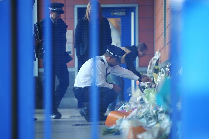 A Metropolitan Police officer looks at floral tributes inside Croydon Custody Centre on September 25.