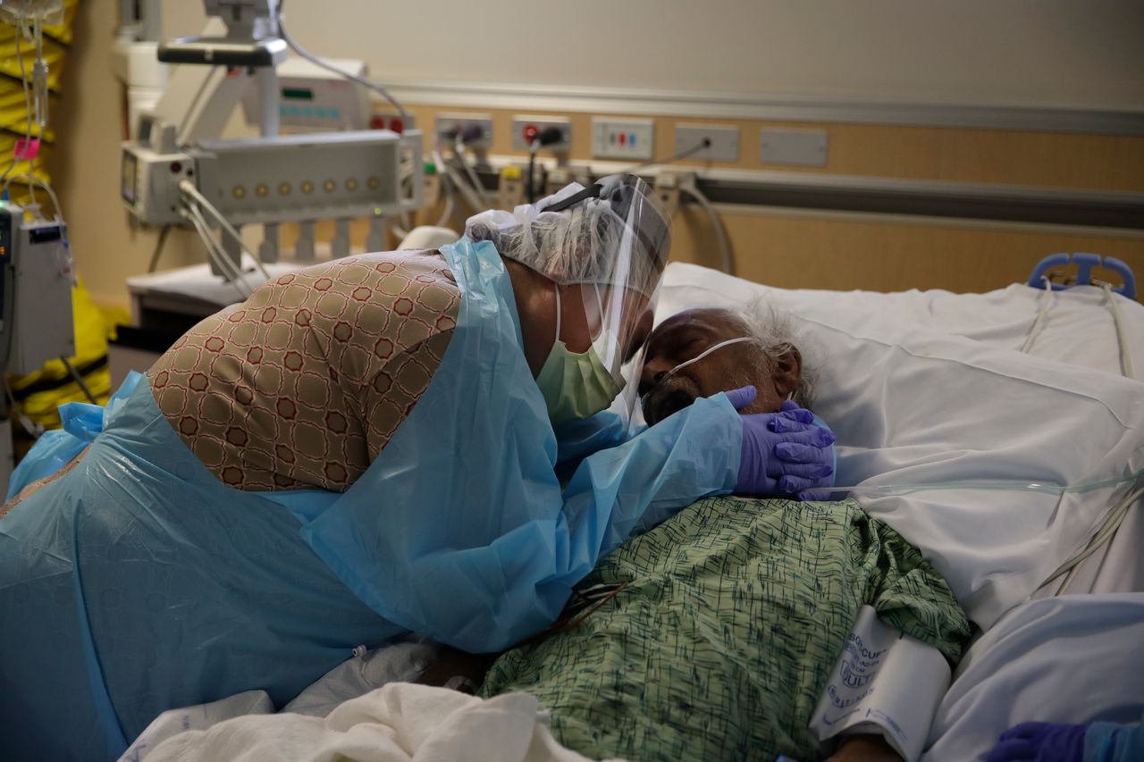 Η Ρομέλια Ναβάρο,, 64 ετών αγκαλιάζει τον άντρα της Αντόνιο, στις τελευταίες του στιγμές, σε νοσοκομείο COVID-19 στην Καλιφόρνια, 31 Ιουλίου 2020. (AP Photo/Jae C. Hong)
