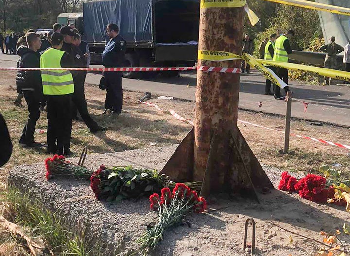 In this photo provided by the Emergency Situation Ministry, flowers lay at the scene where the AN-26 military plane crashed o