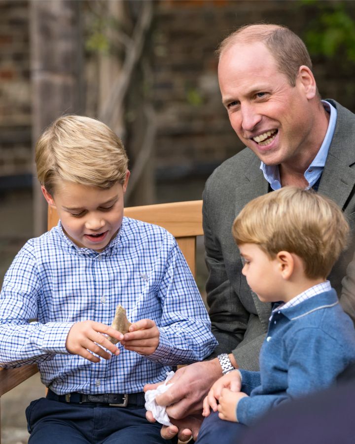 The Duke of Cambridge and Prince Louis watch as Prince George holds the tooth of a giant shark given to him by Sir David Attenborough.