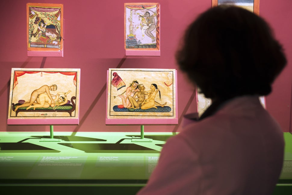 A woman looks at paintings as she visits the exhibition The Kama-Sutra : spirituality and erotism in Indian art, at the Paris' pinacotheque on October 1, 2014 in Paris. The exhibition takes place from October 2 2014 until January 11, 2015. AFP PHOTO / LIONEL BONAVENTURE (Photo credit should read LIONEL BONAVENTURE/AFP via Getty Images)