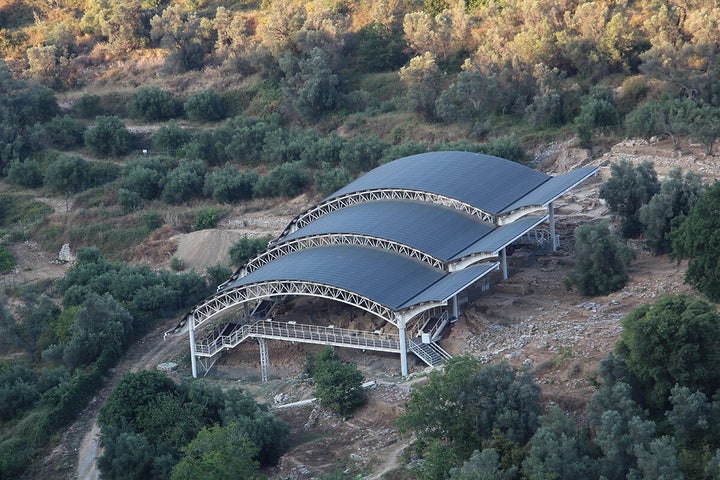 Το τριβαθμιδωτό στέγαστρο πάνω από τη Νεκρόπολη της Ορθής Πέτρας. Προστατεύει με χάλκινες «ασπίδες» τα οστά των Ελευθερναίων της αρχαιότητας και τις ταφικές κατασκευές. Λειτουργεί ως υπαίθριο μουσείο.