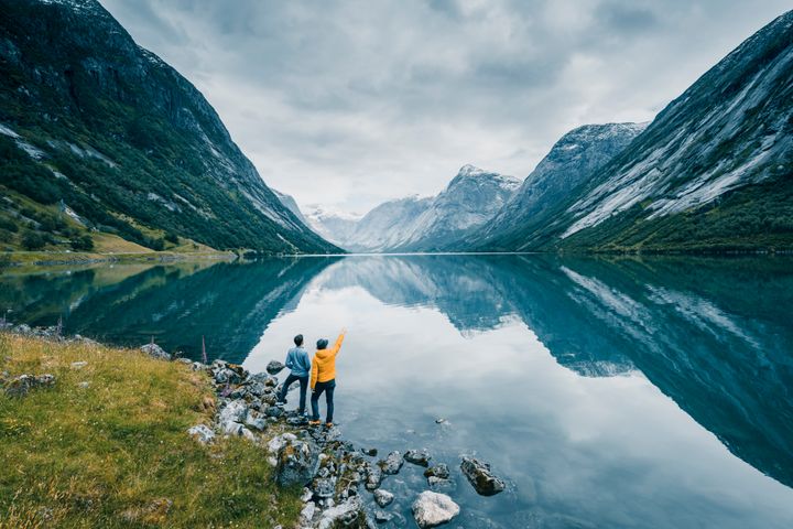 Friends admiring the view on the banks of a norwegian fjord, Norway