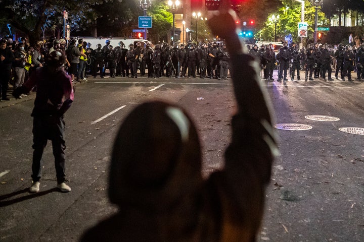 Anti-racism protesters and police face off in the streets of Portland on Saturday. More than a dozen people were arrested.