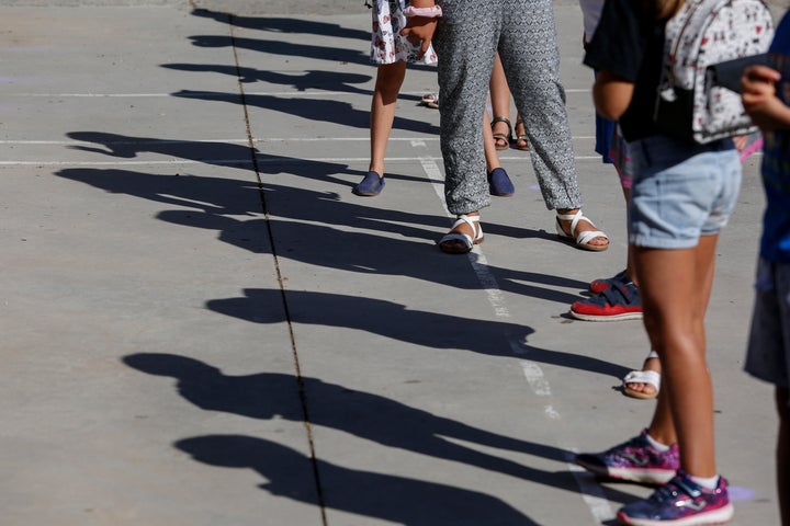 Una fila de niños espera para entrar a su cole, en Granada. 