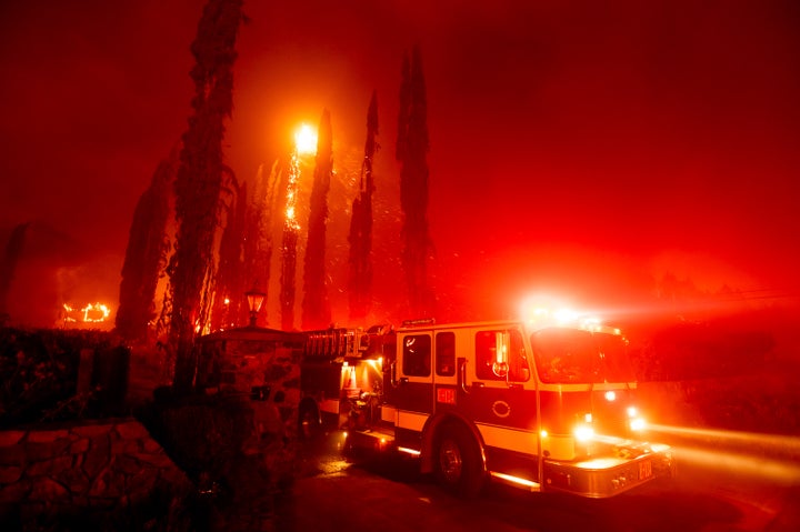 A fire engine leaves a burning property as the Glass Fire tears through St. Helena, Calif., on Sunday, Sept. 27, 2020. (AP Ph