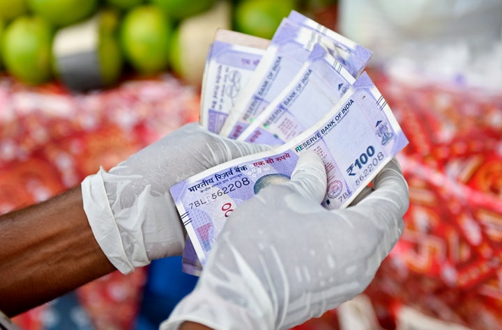 A man counts currency in front of a fruit market in Kolkata, India, 10 September, 2020. India's retail inflation likely stayed above Reserve Bank Of India's medium-term target range in August for the fifth month as the supply disruptions kept food and fuel prices high according to an Indian media report. (Photo by Indranil Aditya/NurPhoto via Getty Images)