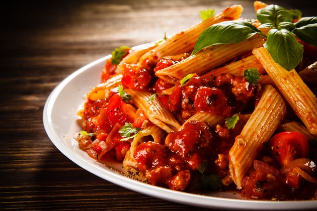 Pasta with meat, tomato sauce and vegetables on white background