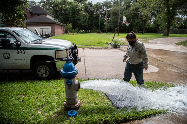 A Lake Jackson water waste operator flushes water from a fire hydrant on Monday in Lake Jackson, Texas, after a brain-eating
