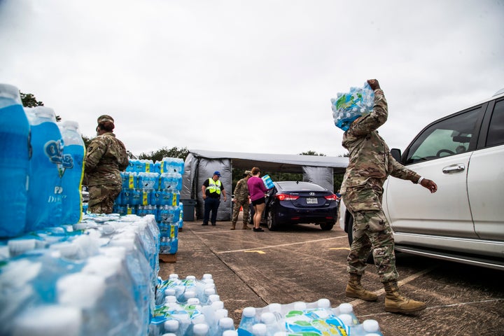 National Guard soldiers and local government employees distribute bottled water to residents in Lake Jackson on Monday. Texas