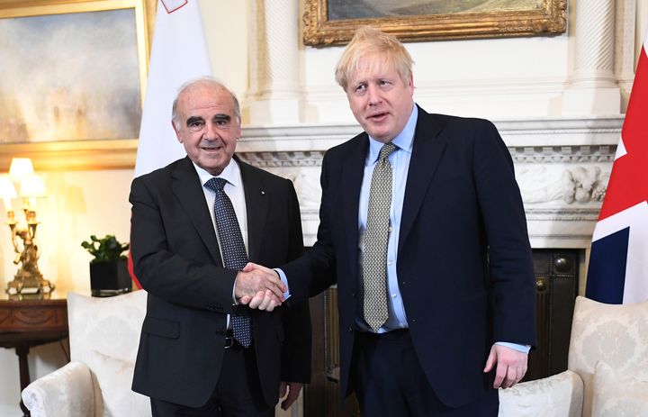 Boris Johnson poses for a handshake with the president of Malta. George Vella, at Downing Street on March 5.