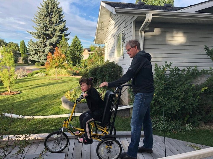 Duane Froese and Annika head to school, on her adapted bike. 