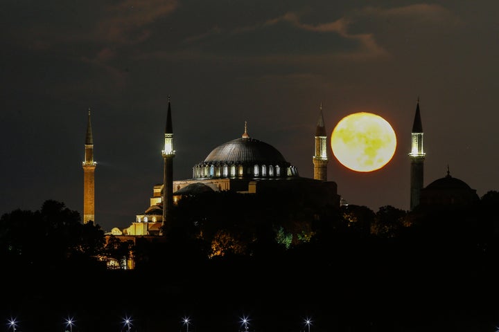 The full moon rises behind the Byzantine-era Hagia Sophia, in the historic Sultanahmet district of Istanbul, early Tuesday, Sept. 1, 2020.