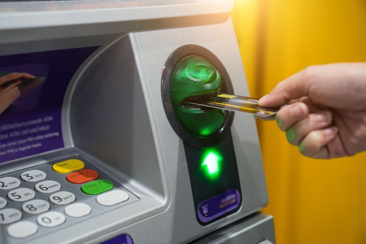 Woman hand is inserting card to atm machine to withdraw or transfer money