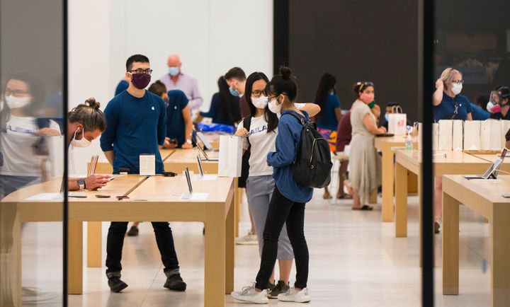 Customers wearing face masks shop at an Apple store in Toronto, Ontario, July 7, 2020. Canada's economic recovery from the spring lockdowns slowed down in August, Statistics Canada says.