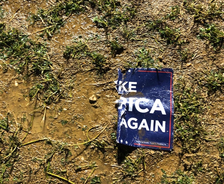 A torn "Make America Great Again" sign sits in the mud on the farm in Lititz, where some 1,000 Trump supporters gathered to watch the first presidential debate.