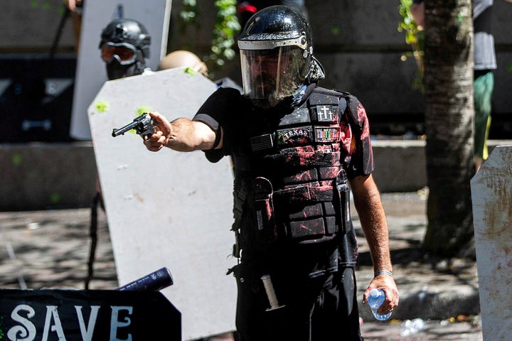 Alan Swinney points a gun during clashes between far-right groups and anti-fascist protesters in Portland, Oregon, on Aug. 22, 2020. 