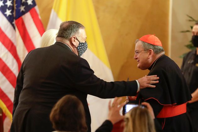 U.S. Secretary of State Mike Pompeo, left, greets Cardinal Raymond Burke as they attend the 