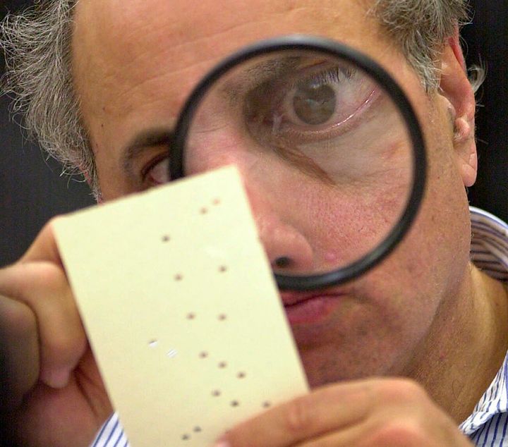One of the indelible images of the haggling over the Florida vote count concerned "hanging chads" on some of the ballots. Here, an election official in Broward County examines with a magnifying glass one of the disputed ballots.