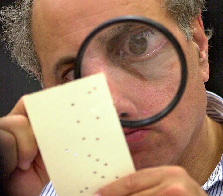 One of the indelible images of the haggling over the Florida vote count concerned "hanging chads" on some of the ballots. Here, an election official in Broward County examines with a magnifying glass one of the disputed ballots.