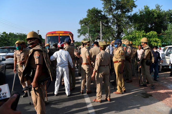 Uttar Pradesh police vacate a road block by Congress party activists outside Bool Garhi village, where the 19-year-old woman who was allegedly gang-raped by four men lived, in Hathras in Uttar Pradesh on September 30, 2020.