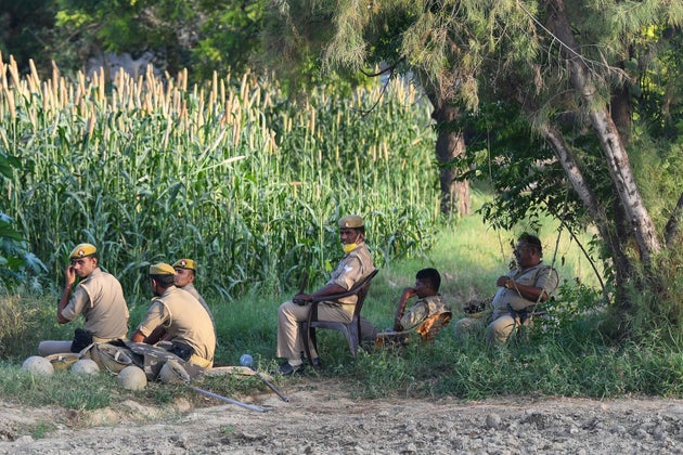 Uttar Pradesh Police personnel stand guard on the outskirts of Bool Garhi village, where the 19-year-old...