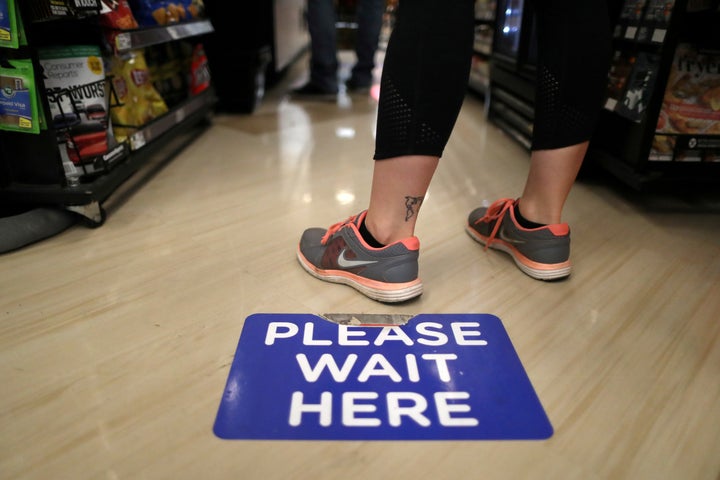 Grocery Chains Fined For Allegedly Endangering Workers During Pandemic 4 Social distancing decals are seen on the floor of a Ralphs grocery store in Los Angeles.