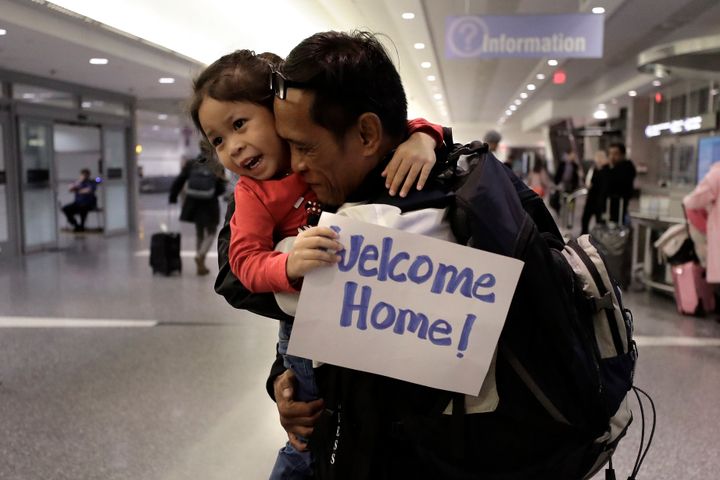 Thy Chea, of Lowell, Mass., center right, hugs his daughter on his arrival at Boston's Logan Airport, Wednesday, Feb. 26, 2020. Chea is the fourth Cambodian refugee to be allowed back into the country after being deported, according to Asian American organizations.