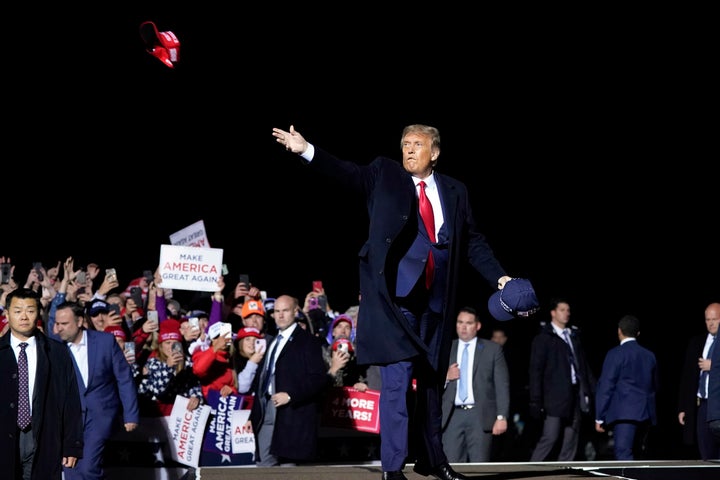 President Donald Trump throws hats to supporters after speaking at a campaign rally at Duluth International Airport, Wednesda
