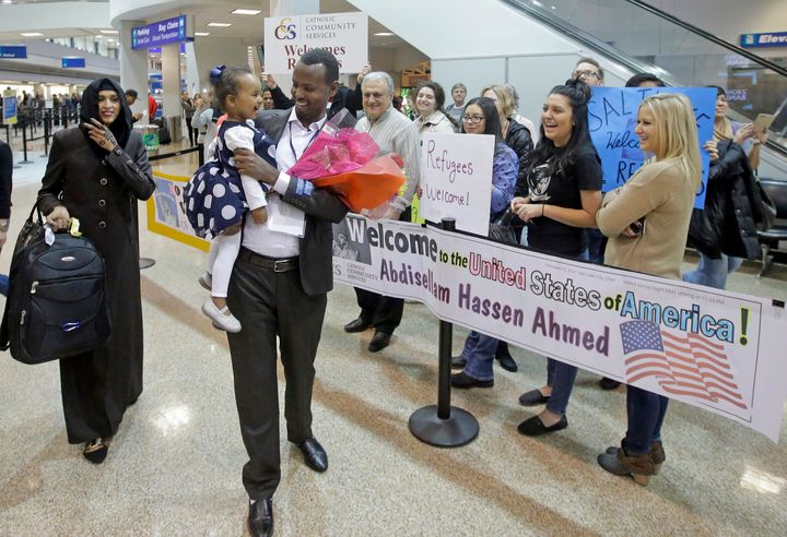 In this Feb. 10, 2017, file photo, Abdisellam Hassen Ahmed, a Somali refugee, walks with his wife Nimo Hashi, and his 2-year-old daughter, Taslim, who he met for the first time after arriving at Salt Lake City International Airport. 