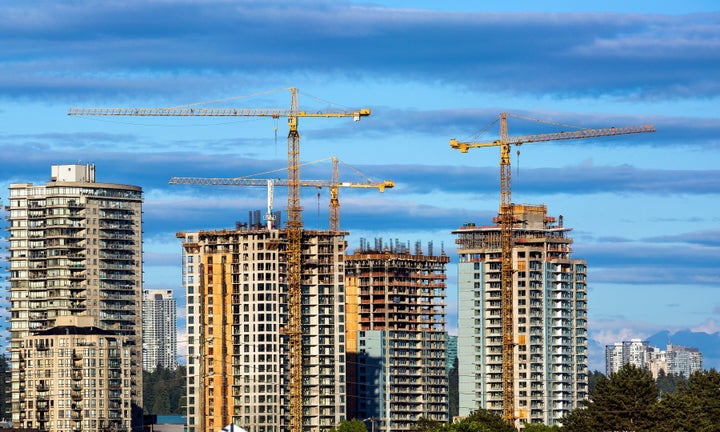 Condo towers under construction stand next to apartment buildings in New Westminster, B.C., in this undated stock photo. For the first time, Canadian renters can have their rent count towards their credit rating, under a new arrangement with Equifax and the Landlord Credit Bureau.