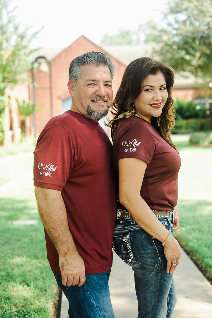 The couple wearing matching "Our Nest, Est. 1986" T-shirts. 