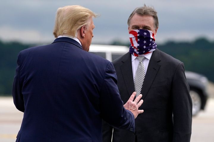 Trump greets Senator David Perdue as he arrives at Dobbins Air Reserve Base for a campaign event at the Cobb Galleria Centre in Atlanta