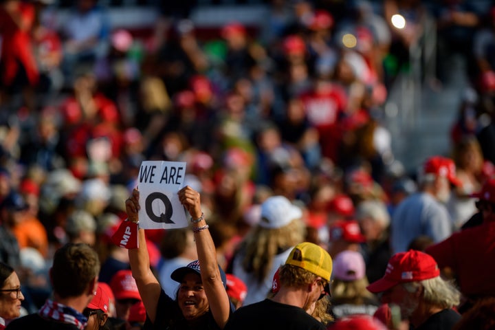 A woman holds up a QAnon sign to the media as attendees wait for President Donald Trump to speak at a Sept. 22 campaign rally at Atlantic Aviation in Moon Township, Pennsylvania.