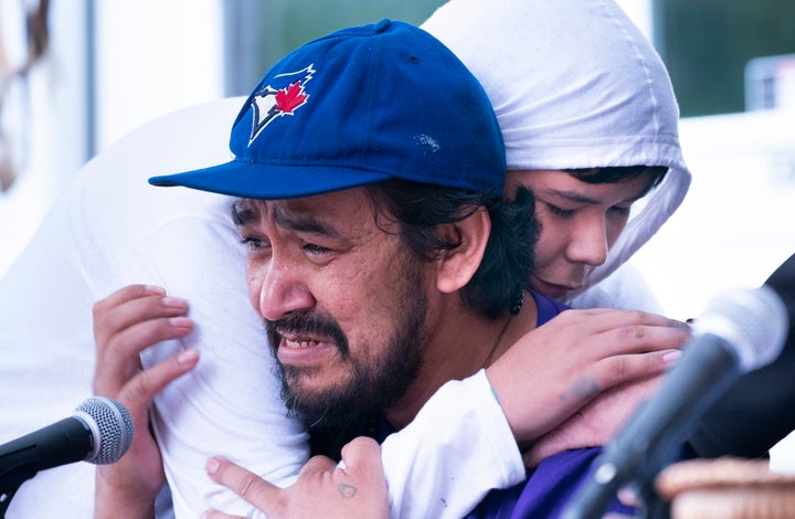 One of Joyce Echaquan's son, Dayvon, hugs his father Carol Dubé as he addressed the media on Friday about the death of his wife.