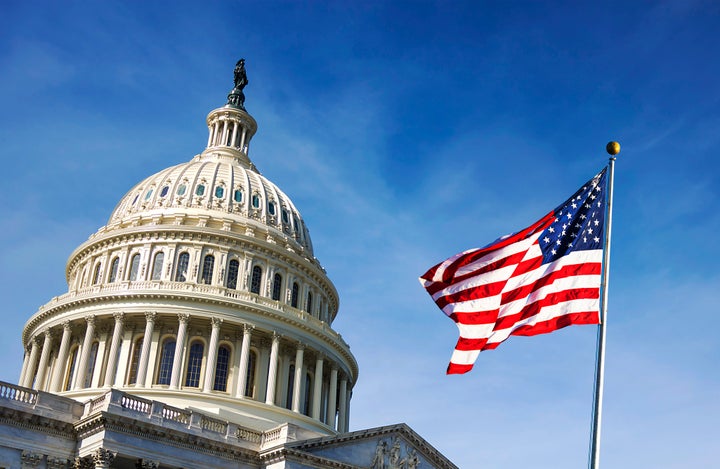 American flag waving with the Capitol Hill in the background