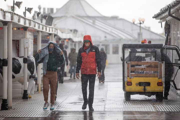 People walk along Brighton Pier during heavy rain on Friday.