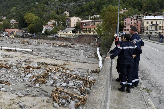 Des riverains et des pompiers le 3 octobre sur un pont de Roquebillière regardant les dégâts provoqués...