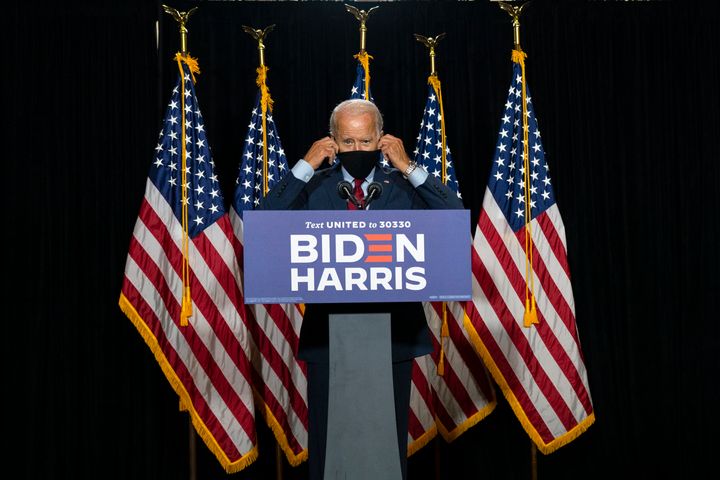 Former Vice President Joe Biden removes his face mask as he arrives to speak at a campaign event in August.