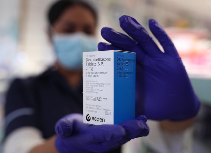 A member of staff at a pharmacy in London holds a packet of anti-inflammatory drug dexamethasone, which has been hailed as a ground-breaking treatment for hospital patients seriously ill with COVID-19.