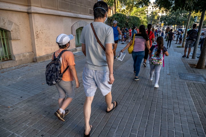 Padres acompañando a sus hijos al colegio.