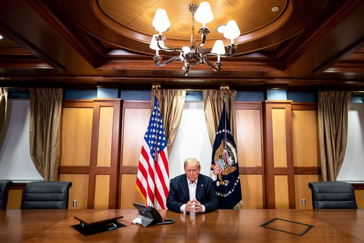President Donald Trump listens during a phone call with Vice President Mike Pence, Secretary of State Mike Pompeo, and Chairman of the Joint Chiefs of Staff Gen. Mark Milley, Sunday, Oct. 4, 2020, in his conference room at Walter Reed National Military Medical Center in Bethesda, Md.
