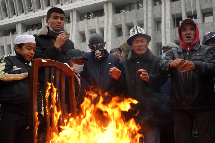 Protesters gather by a bonfire outside the White House building that houses Kyrgyzstan's Presidential Administration and Parliament, seized by participants in protests against the results of the 2020 Kyrgyz parliamentary election. 