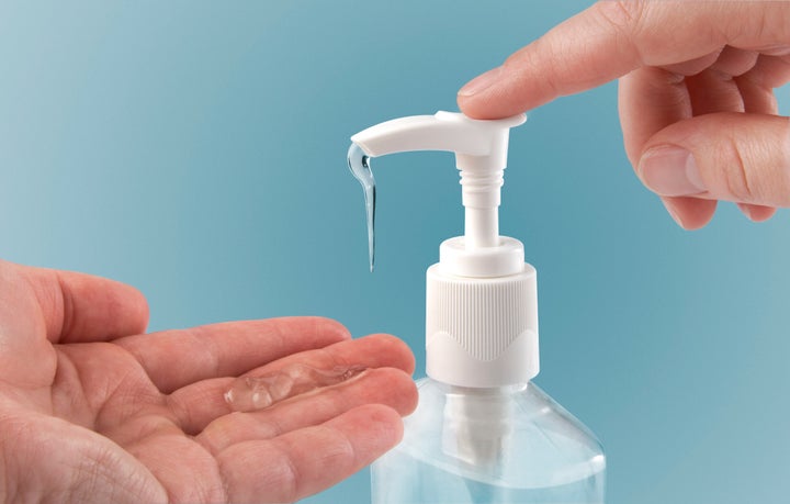 Pumping hand sanitizer into hand.