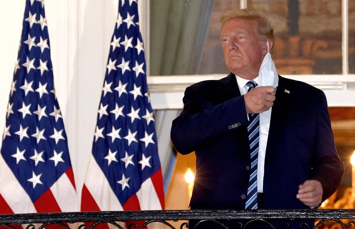 President Donald Trump made a point of removing his mask upon returning to the White House Monday night after being hospitali