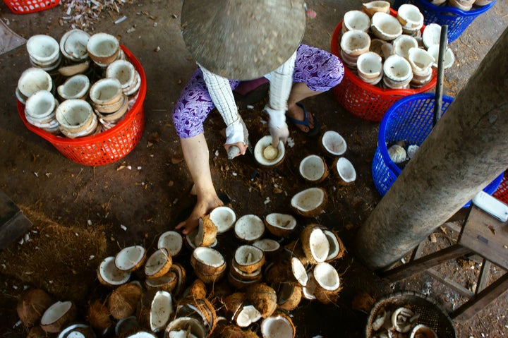 Un travailleur s'affaire à la fabrication de friandises avec des noix de coco dans la région du delta du Mékong, au Vietnam.