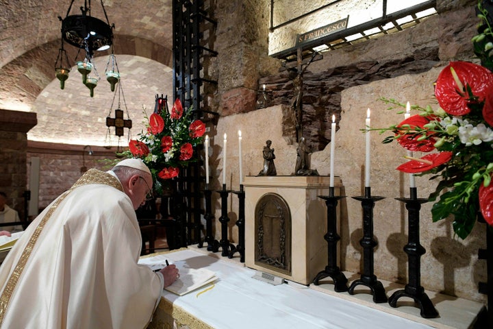 Pope Francis signs his new encyclical in front of St. Francis' tomb on Oct. 3, 2020, in Assisi, Italy. On the anniversary of the saint's death, Pope Francis celebrated Mass and signed his latest papal letter, "Fratelli Tutti."