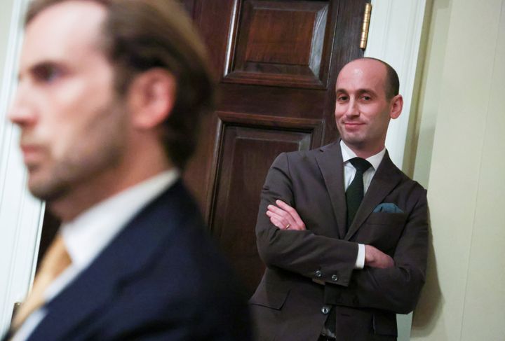 Stephen Miller watches from a corner of the room as Trump holds an executive order signing event in August.