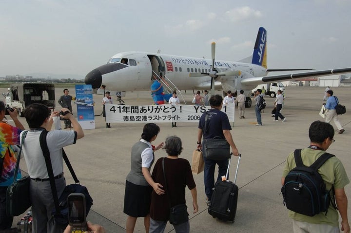 YS-11のラストフライトに向かう搭乗客。「41年間ありがとう！」と横断幕が掲げられた＝2006年9月30日、徳島空港。朝日新聞社撮影